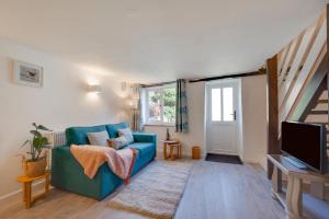 a living room with a blue couch and a tv at 1 Bed in Parracombe oc-smitho in Trentishoe