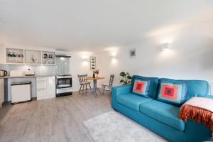 a living room with a blue couch and a kitchen at 1 Bed in Parracombe oc-smitho in Trentishoe