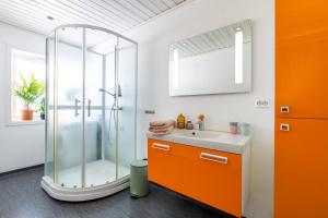 an orange bathroom with a shower and a sink at Tromsø Panorama in Tromsø +46 photos