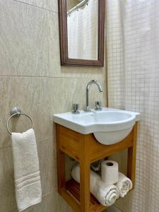 a bathroom with a sink and a mirror and towels at Hotel Riviera in Santa Teresita