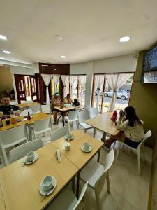 a group of people sitting at tables in a restaurant at Hotel Riviera in Santa Teresita