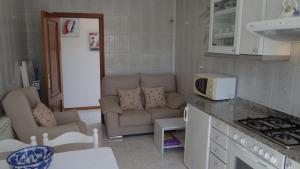 a kitchen with a couch and a living room at Casa Bruna 1º A Apartamento a 800 m de la playa in Lariño +4 photos