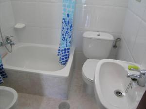 a bathroom with a white toilet and a sink at Casa Bruna 1º A Apartamento a 800 m de la playa in Lariño