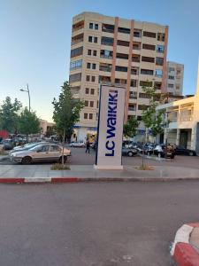 a sign in front of a parking lot with a building at Beautiful Apartment Hamria in Meknès