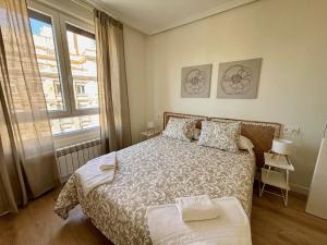 a bedroom with a bed and a large window at Espacios Blanco Santiago in Valladolid