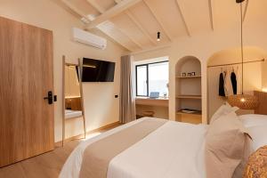 a bedroom with a white bed and a tv at 2Luxury Provenza: Htd Pool, Jacuzzi, BBQ, Pool in Medellín