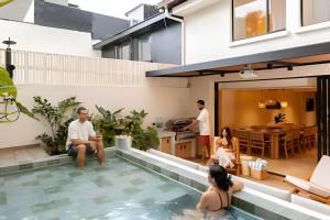 a group of people sitting in the swimming pool of a house at 2Luxury Provenza: Htd Pool, Jacuzzi, BBQ, Pool in Medellín