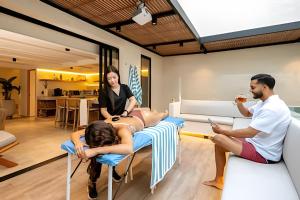 a woman laying on a table in a room with two people at 2Luxury Provenza: Htd Pool, Jacuzzi, BBQ, Pool in Medellín +85 photos