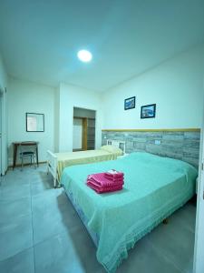 two beds in a room with blue lighting at Hotel Riviera in Santa Teresita