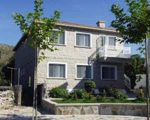 a house with a balcony on the side of it at Casa Bruna Baixo A Apartamento a 800 m de la playa in Lariño