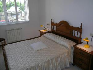 a bedroom with a large bed and two night stands at Casa Bruna Baixo A Apartamento a 800 m de la playa in Lariño