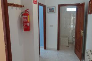 a fire hydrant is hanging on the wall of a bathroom at Casa Bruna Baixo A Apartamento a 800 m de la playa in Lariño
