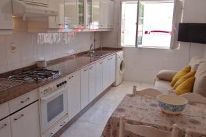 a kitchen with white cabinets and a table with a table sidx sidx sidx at Casa Bruna Baixo A Apartamento a 800 m de la playa in Lariño +9 photos