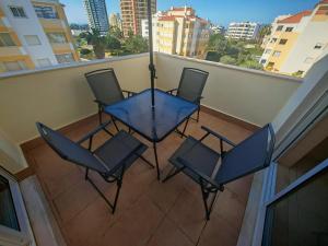 a balcony with a blue table and chairs on a balcony at Buzios Praia da Rocha in Portimão