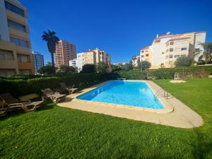 a swimming pool in a yard next to some buildings at Buzios Praia da Rocha in Portimão