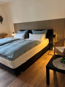a bedroom with a large bed with blue sheets and white pillows at Tarrazza Ferienwohnungen Erpeldinger in Ellenz-Poltersdorf