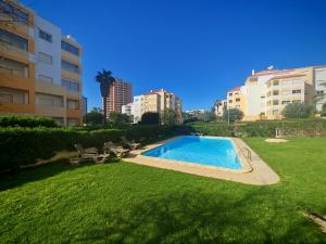 a swimming pool in a yard next to some buildings at Buzios Praia da Rocha in Portimão +38 photos