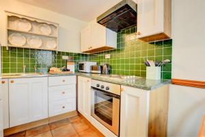 a kitchen with white cabinets and green tiles at 2 Bed in Leyburn oc-ds902 in Askrigg