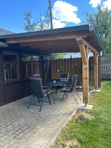 a pavilion with a table and chairs on a patio at Ferienhaus "Oybinblick" in Oybin