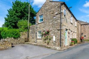 an old stone house with flowers in front of it at 2 Bed in Leyburn oc-ds902 in Askrigg