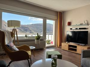 a living room with a large window and a television at Tarrazza Ferienwohnungen Erpeldinger in Ellenz-Poltersdorf