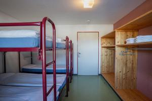 a room with two bunk beds and a doorway at Gruppenhaus Frutigresort in Frutigen +15 photos