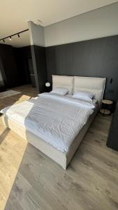 a large white bed in a room with wood floors at Bavaro apartments 2 in Ivano-Frankivsk