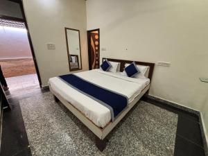 a bedroom with a large bed with blue pillows at Hotel Star Inn , Pushkar in Pushkar