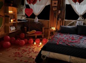 a bedroom with balloons and a bed with candles at Cabaña el Leñador in Santa Elena