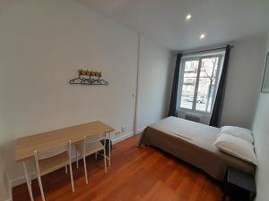 a bedroom with a bed and a table and a window at Budget Hôtel Weber - Strasbourg Centre Gare in Strasbourg