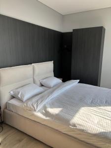 a white bed with two pillows on top of it at Bavaro apartments 2 in Ivano-Frankivsk