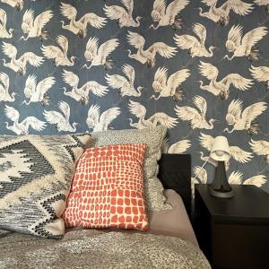 a bedroom with a wall with white birds wallpaper at Raday Bobo in Budapest