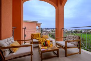 a porch with two chairs and a coffee table on a balcony at Ethereal Residence by Nomads in Paphos