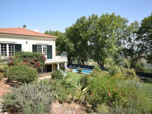 a house with a garden and a swimming pool at Cozy Villa with Private Swimming Pool in Carreiros