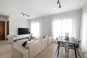 a white living room with a couch and a table at Ethereal Residence by Nomads in Paphos