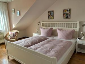 a bedroom with a large white bed with pink pillows at Grandezza Ferienwohnungen Erpeldinger in Ellenz-Poltersdorf