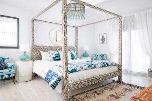 a bedroom with a canopy bed with blue pillows at Boho Lux in Atlanta