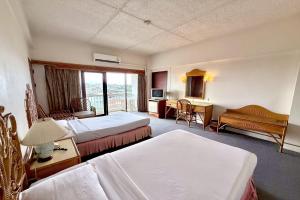 a hotel room with two beds and a balcony at Pailyn Hotel Phitsanulok in Phitsanulok +120 photos