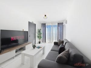 a living room with a couch and a flat screen tv at Stylish Seaview Retreat in St Pauls Bay in St. Paul's Bay