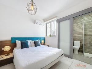 a bedroom with a large bed and a toilet at Stylish Seaview Retreat in St Pauls Bay in St. Paul's Bay
