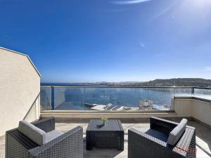 a balcony with two chairs and a table and a view of the water at Stylish Seaview Retreat in St Pauls Bay in St. Paul's Bay