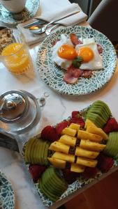 two plates with eggs and fruit on a table at Casa Zogbi Hotel in Porto