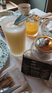 a table topped with plates and glasses of orange juice at Casa Zogbi Hotel in Porto