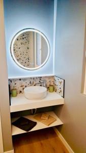 a bathroom with a sink and a mirror at Appartement cosy ambiance Malibu dans résidence avec piscine 2 pers 1 chambre in Neuf-Mesnil +15 photos