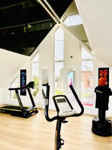 a room with a gym with a treadmill and a person at Appartement cosy ambiance Malibu dans résidence avec piscine 2 pers 1 chambre in Neuf-Mesnil