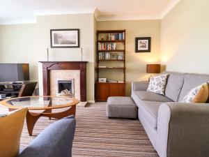 a living room with a couch and a fireplace at Castle Cove in Abergele