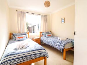 two beds in a room with a window at Castle Cove in Abergele
