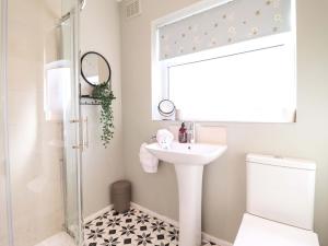 a white bathroom with a sink and a shower at Castle Cove in Abergele +28 photos