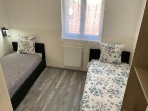 a small room with a bed and a window at Appartement Sun GroupamaLyon Eurexpo in Meyzieu