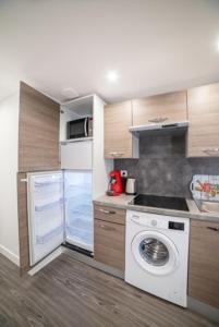 a kitchen with a stove and a washing machine at Appartement Sun GroupamaLyon Eurexpo in Meyzieu